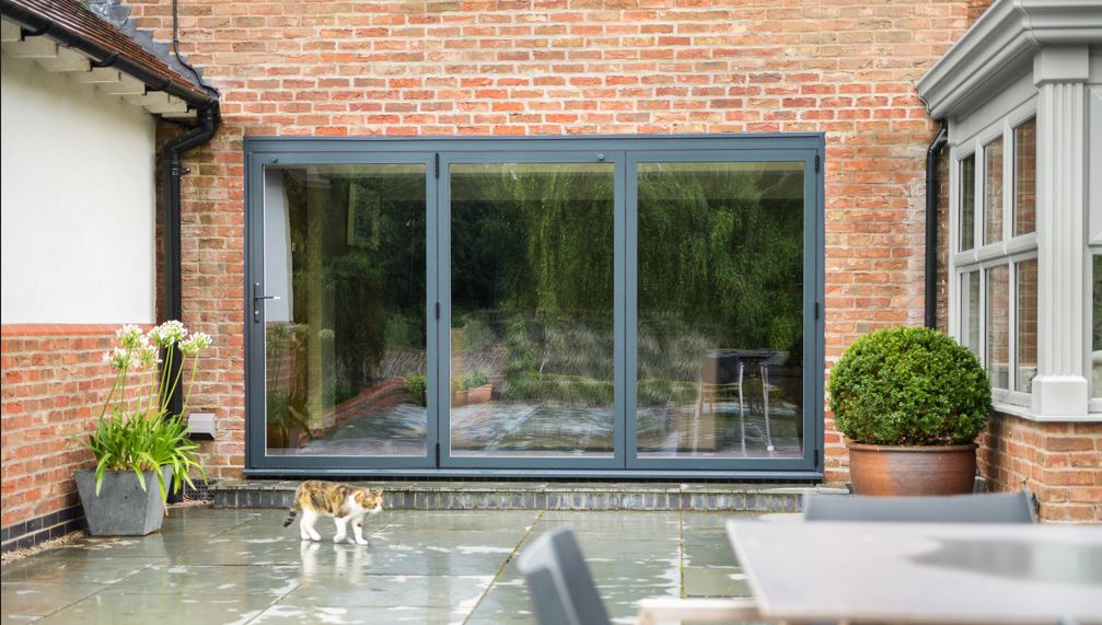 Image of a grey bifolding door viewed from outside a home 